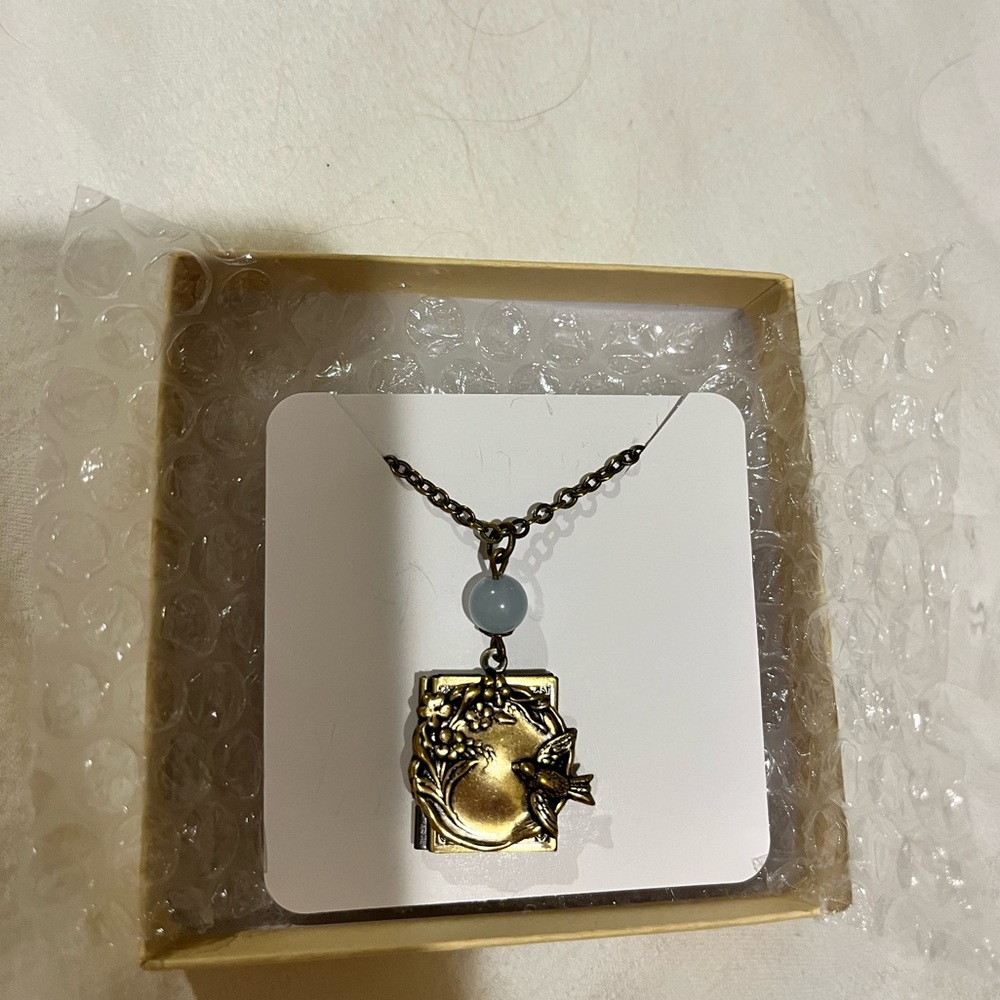 Antique brass book locket with bird & flowers. 18 in chain; blue natural stone.
